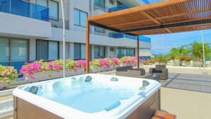 A hot tub area with a wooden pergola, outdoor seating, and flower planters. - Exclusive Apartment Seaview - Samaria Club Playa (Gaira)