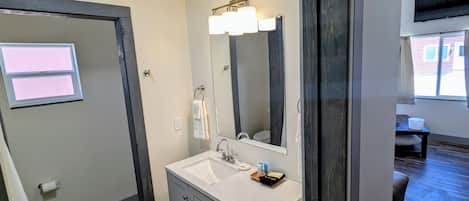 A bathroom with a sink, mirror, and towel rack.