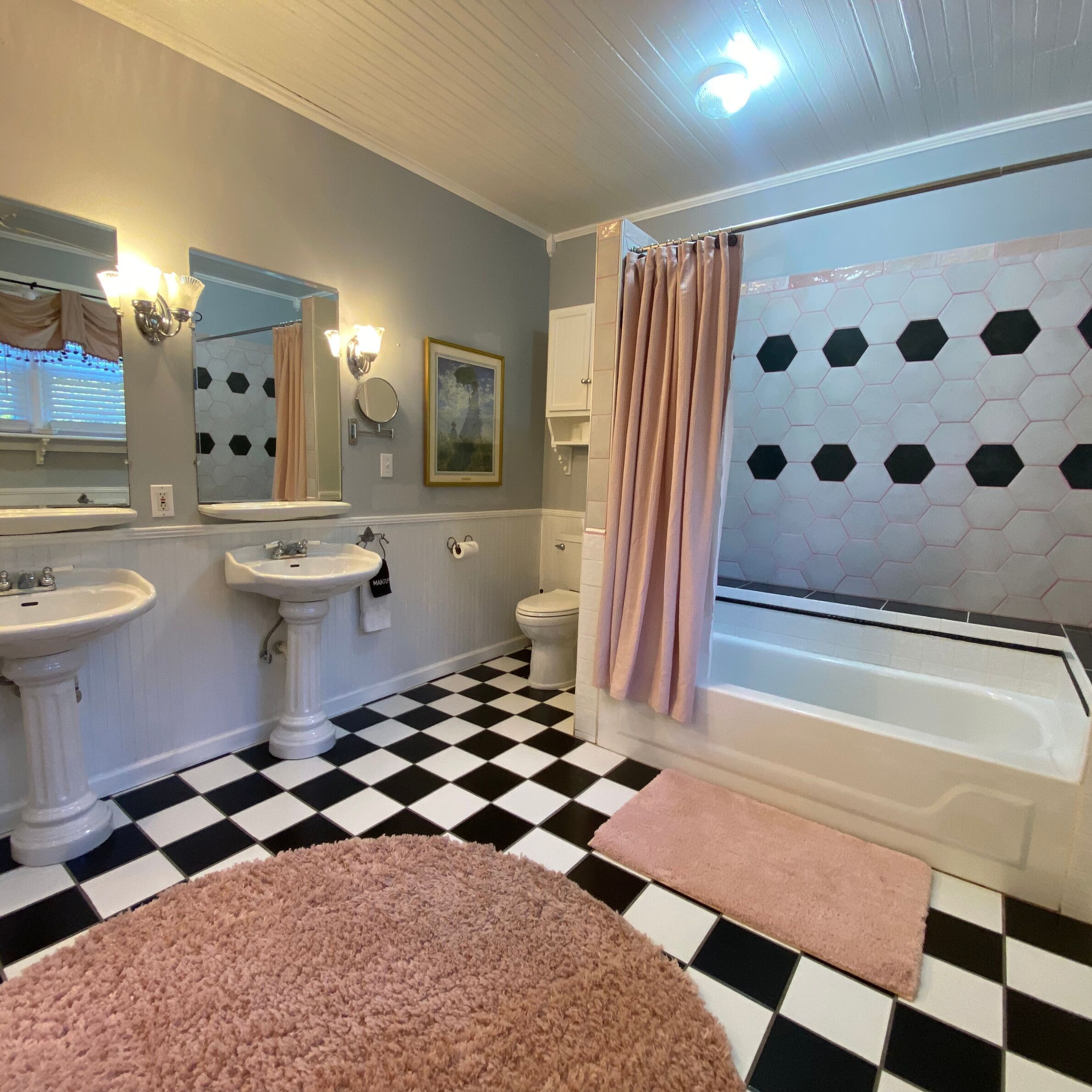 A bathroom with two sinks, a toilet, a bathtub, and a shower curtain.