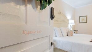 A white door labeled "Magnolia Suite" with a bed in the background. - The Clayton Magnolia Inn (Clayton)