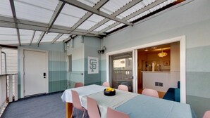 Un salón de conferencias con una mesa, sillas, una puerta y vistas a una cocina.