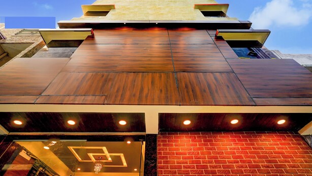 A modern building with a wooden facade and a brick base. - Qubenest Splendour (Bangalore)