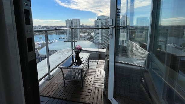 Un balcón con vista a un puerto deportivo y al paisaje urbano.