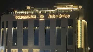 Un edificio con letreros iluminados que indican “GOLDEN SEASON” y “RESTAURANTE & CAFÉ”.