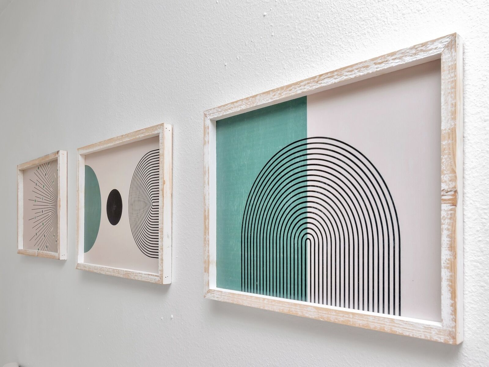 Tres obras de arte enmarcadas en una pared.