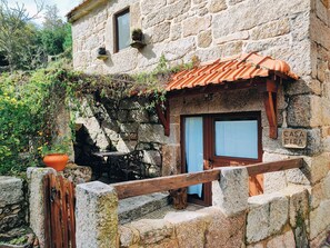 Ein Steinhaus mit einer Holztür und einem Schild mit der Aufschrift 'CASA EIRA'.