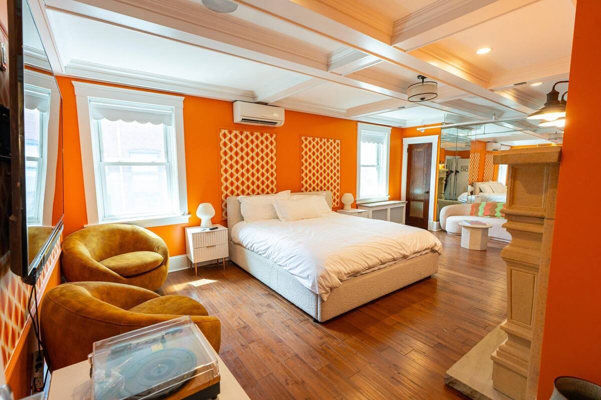 Une chambre moderne avec un grand lit, un canapé et une petite table.