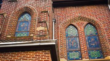 A brick building with two arched stained glass windows.