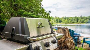 A Broil King grill with a view of a lake and trees in the background.