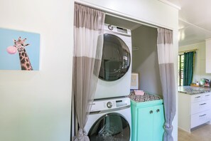 A laundry room with a washing machine, a dryer, and a small cabinet.