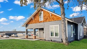 A two-story house with a wooden shingle roof, a garage, and a well-maintained lawn.