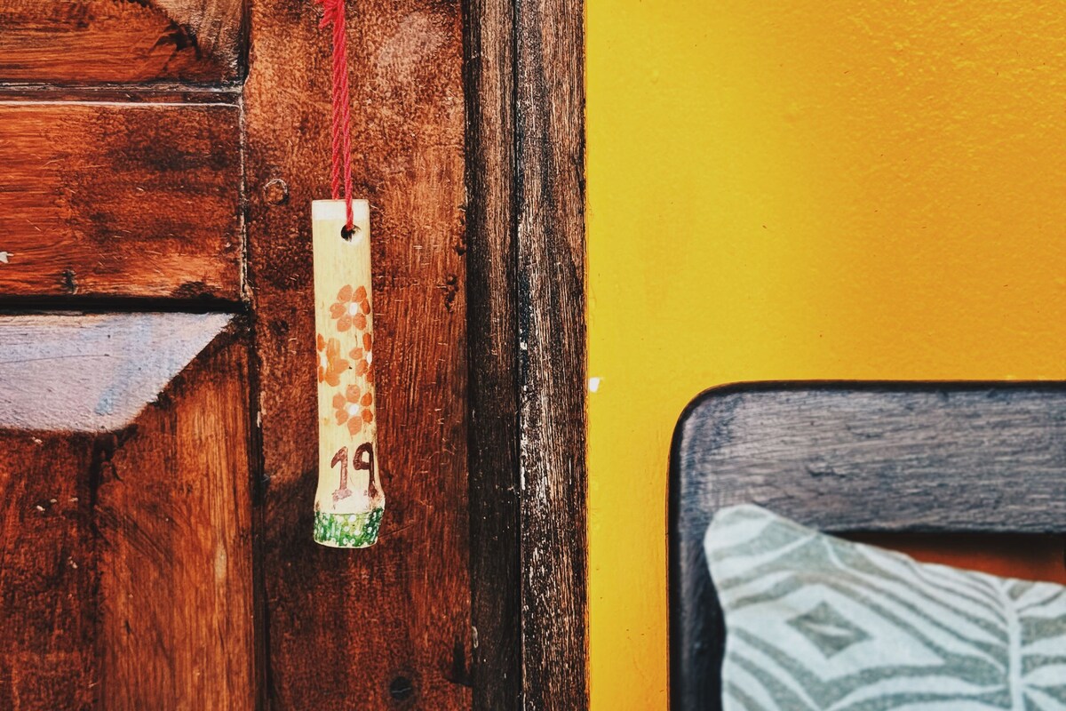 A wooden door with a brass lock and a hanging tag.