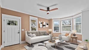 A modern living room with a white sofa, a coffee table, and a ceiling fan.
