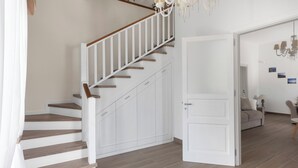 A staircase with white railings and wooden steps leading to a white door.