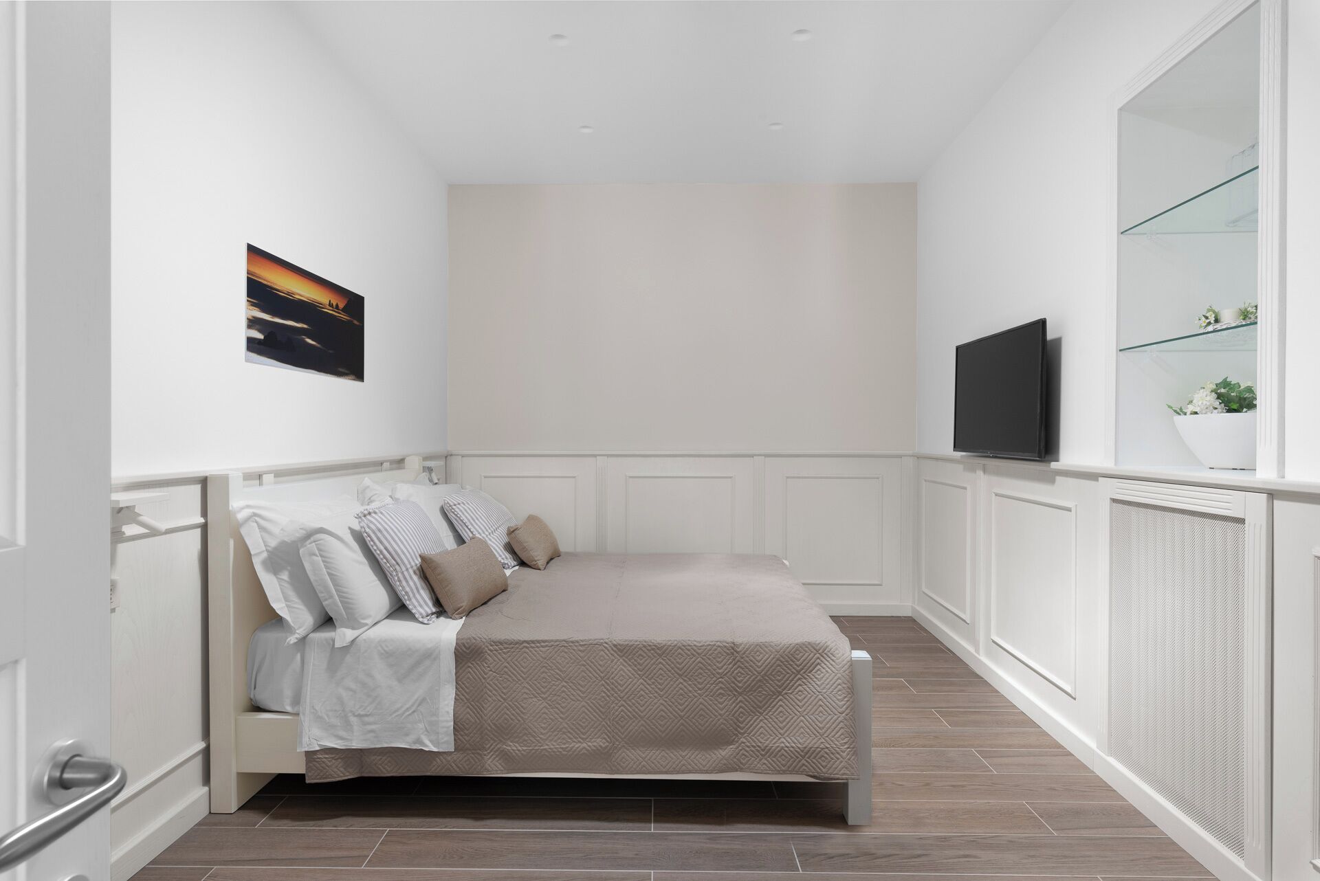 Un dormitorio con cama, televisor y ventana con vistas.