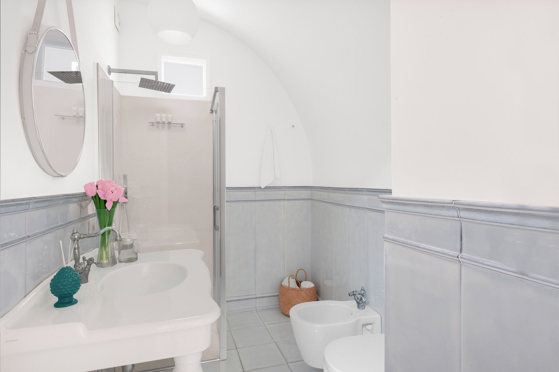 Un baño con lavamanos, inodoro y bidé, que incluye un espejo, ducha y ventana.