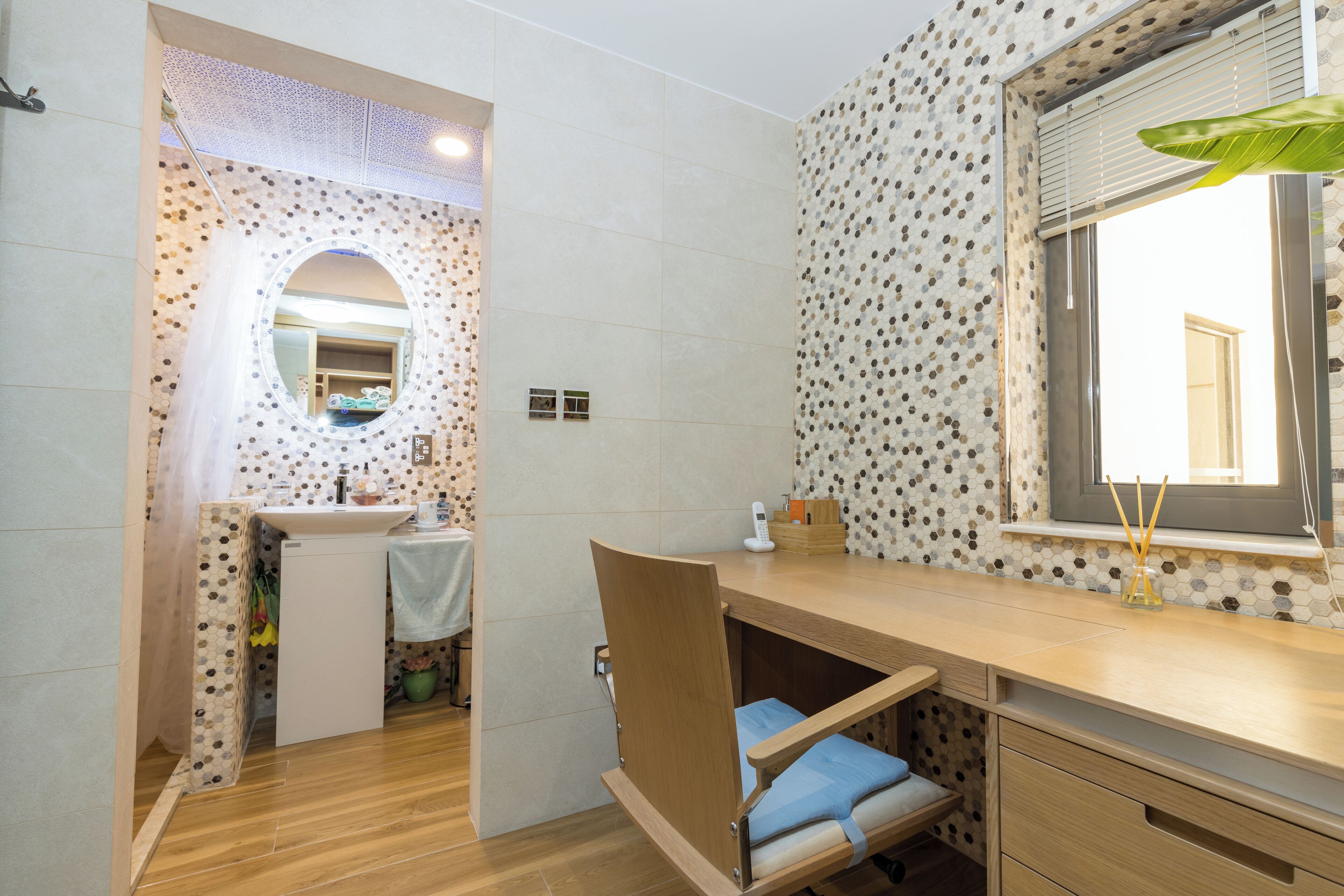 Un baño con tocador de madera, espejo y lavamanos.