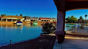 Ein Anwesen am Wasser mit Pool, Booten und einer überdachten Terrasse.