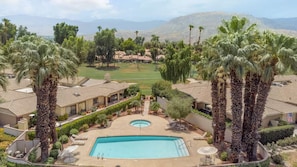 A residential area with a swimming pool, palm trees, and houses with similar architecture. - The Palmer! Monterey Country Club, Hole 6, Resort Amenities! Golf cart included! (Palm Desert)