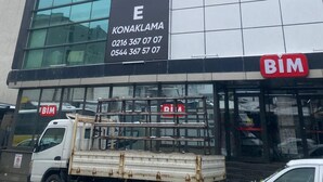 Un edificio con un cartel grande que dice "trio PALACE KONAKLAMA" y números de contacto.