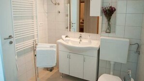 Ein Badezimmer mit Waschbecken, Spiegel und Handtuchhalter.