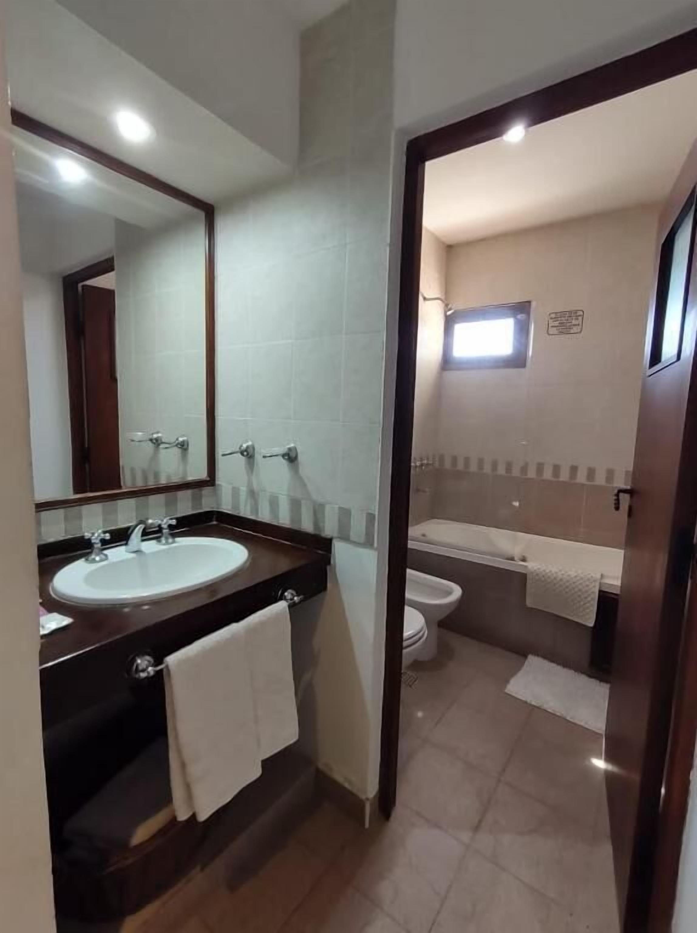 Bañera con ducha, toallas, jabón, shampoo