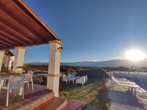 A patio with outdoor seating, a pergola, and a view of mountains. - Hotel Boutique Altos de Amaicha (Amaicha Del Valle)