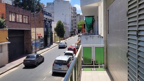 A street view with a building on the right, a sidewalk, and parked cars. - HOTEL RESIDENCIAL CAMACHO (Cordoba)