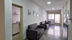 A hallway with a reception area, a waiting area with sofas, and a kitchenette. - HOTEL RESIDENCIAL CAMACHO (Cordoba)