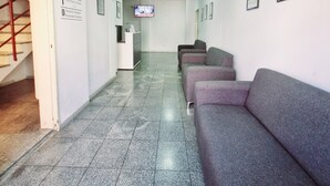A hallway with a reception desk, a TV screen, and a staircase. - HOTEL RESIDENCIAL CAMACHO (Cordoba)
