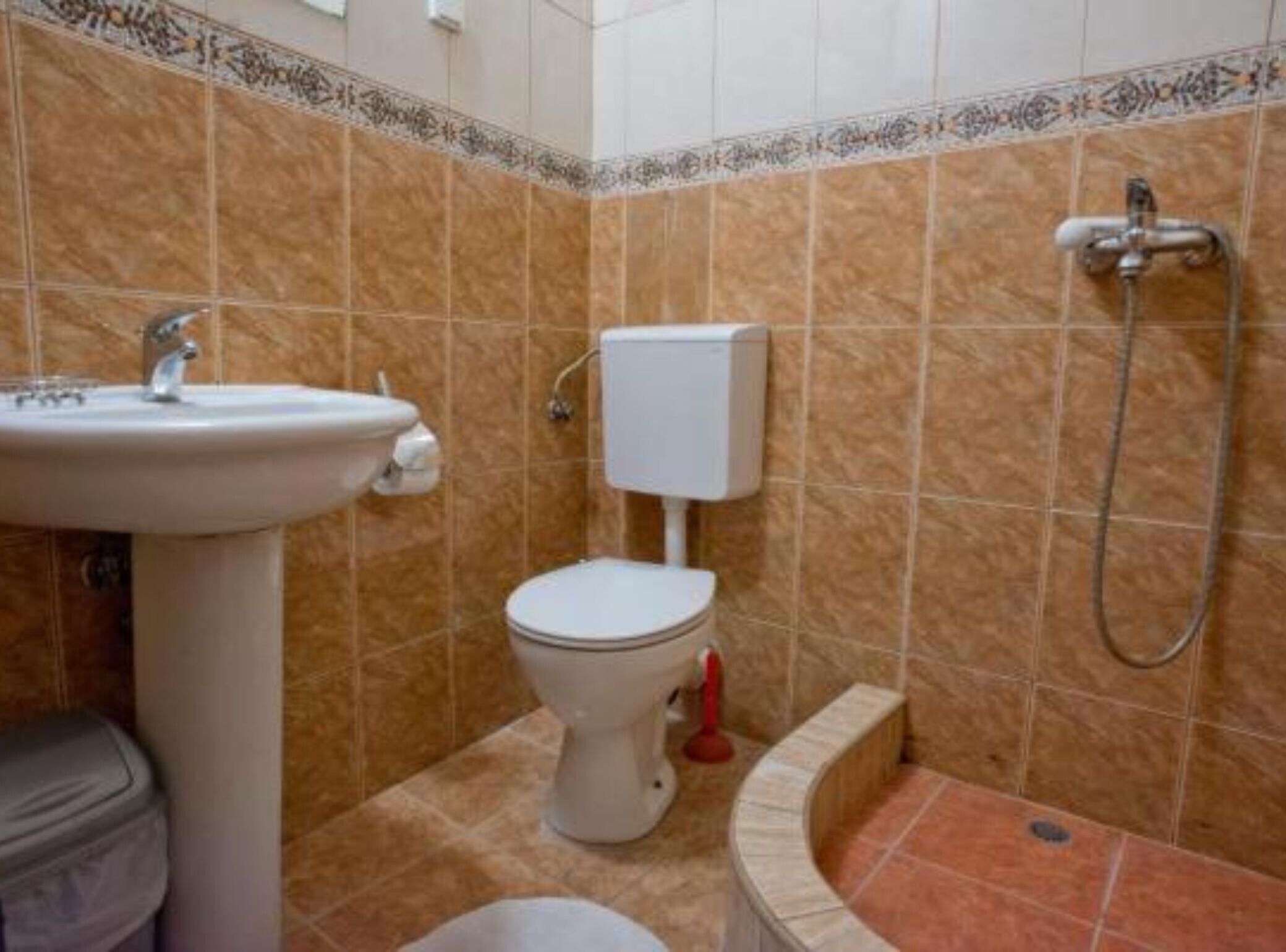 Un bagno con lavandino, WC e doccia.
