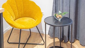 A yellow chair with a unique design, a small round table with a bowl of snacks, and a grey curtain in the background. - Charming and Elegant Rooms Zadar Historic Center - Classic Double room (Zadar)