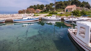 A marina with several boats docked, a clear water body, and a building with a red roof in the background. - One Bedroom Apartment with Balcony (owner Cvita 1) (Zadar)