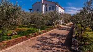 A house with a paved driveway leading to a white building with a red roof. - One Bedroom Apartment with Balcony (owner Cvita 1) (Zadar)