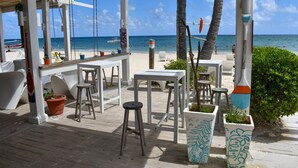 A beachside patio with white furniture, potted plants, and a view of the ocean. - Playa Turquesa Ocean Club, A-203, cozy 1-BR apartment, AC, WiFi, private beach (Bavaro)