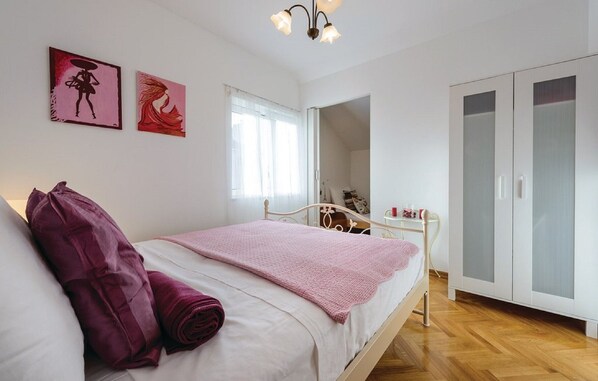 Une chambre à coucher avec un lit, une armoire et des œuvres d’art accrochées au mur.