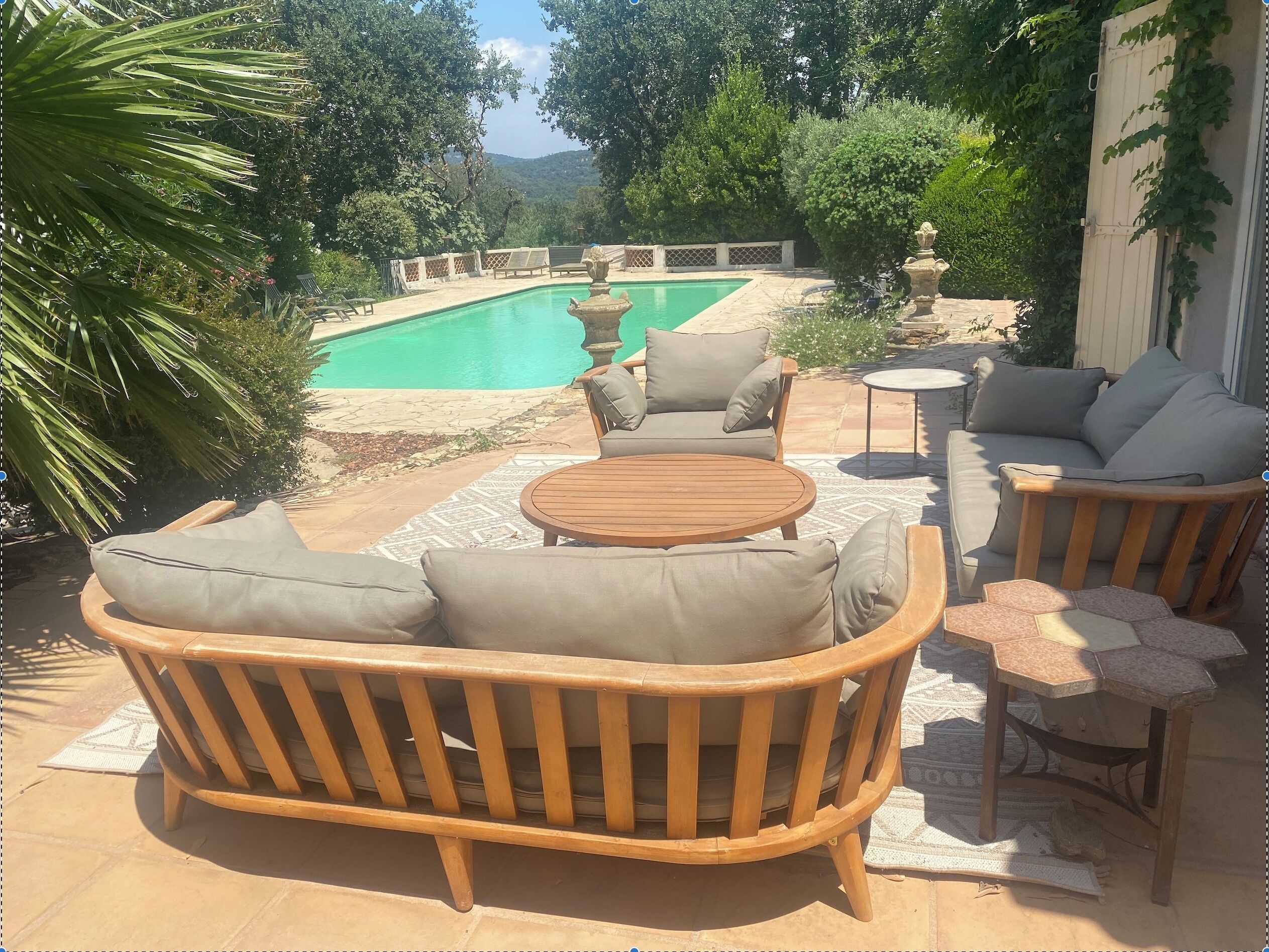 A patio area with a pool, outdoor furniture, and a view of the landscape.