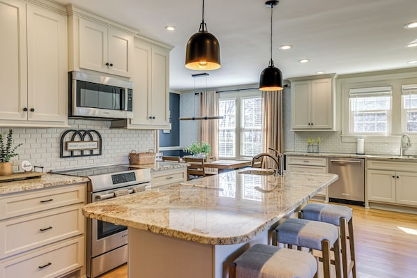 Enjoy cooking in this well-lit kitchen with a large island and appliances.