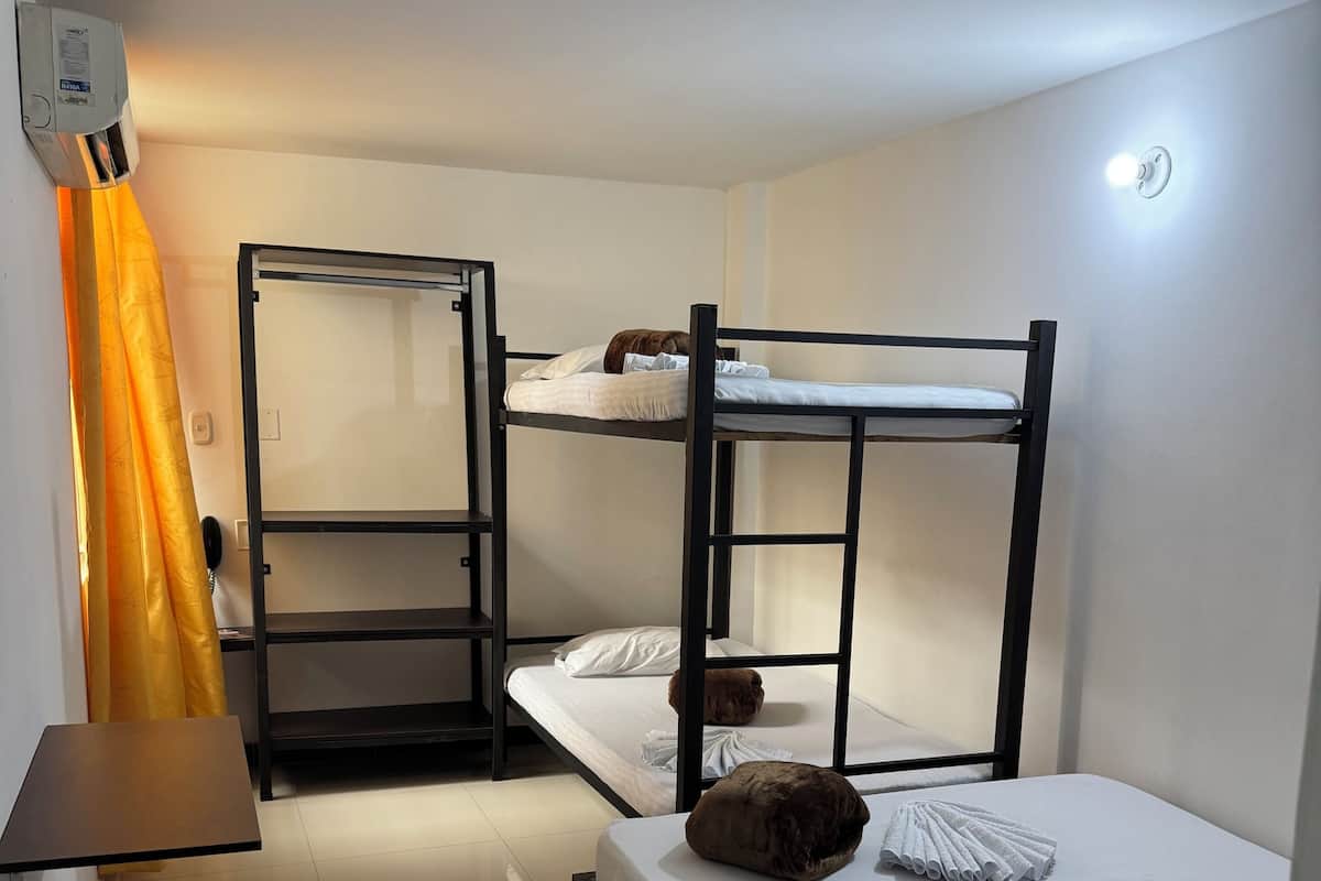 Een kamer met stapelbedden, een bureau, een stoel en een telefoon.