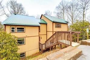 A two-story building with a green roof and wooden exterior.