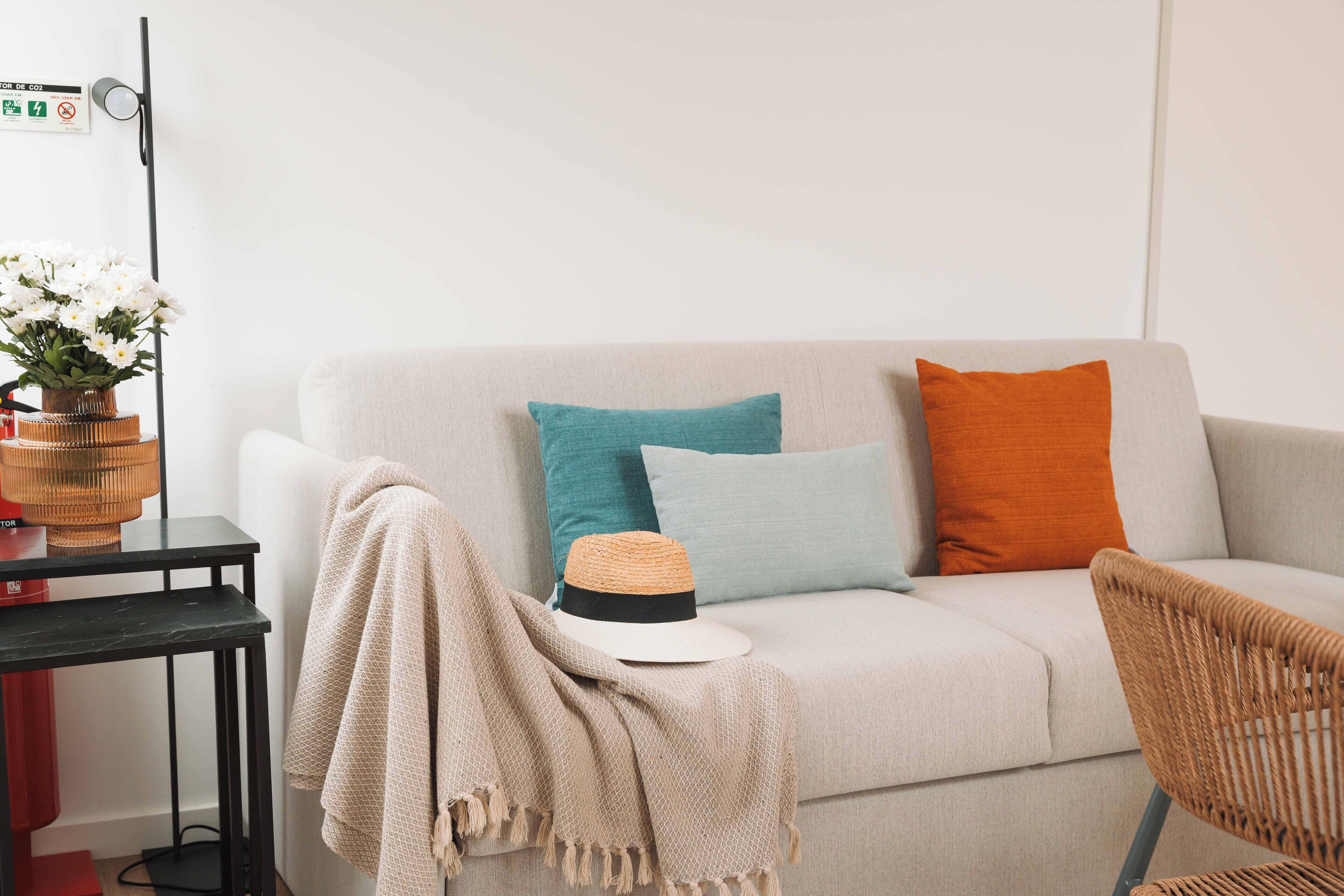 Una sala de estar con un sofá, una silla, una mesa y una lámpara de pared.