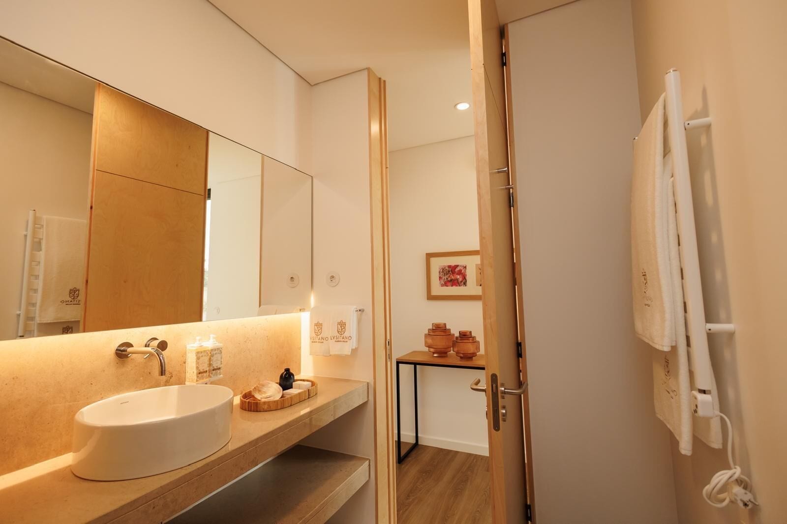 A modern bathroom with a large mirror, a sink, and a shower area.