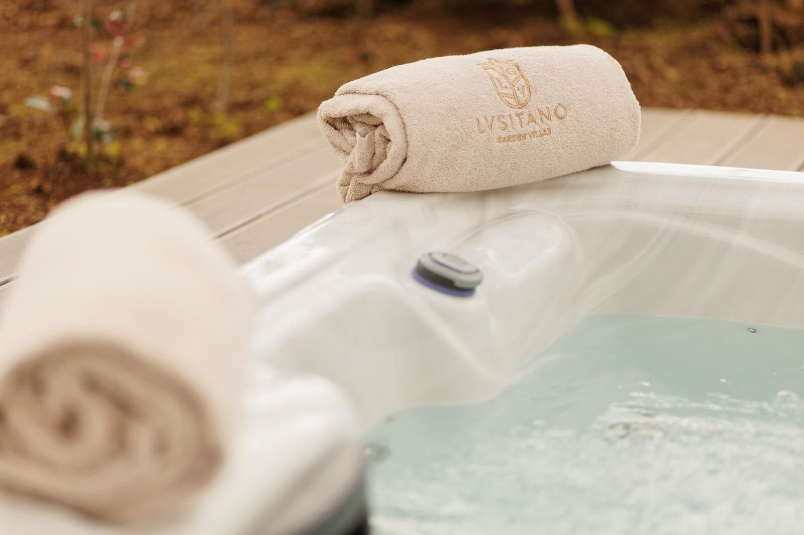 A hot tub with a rolled towel on top and a control panel.