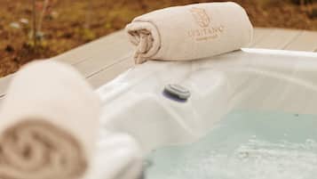 A hot tub with a rolled towel on top and a control panel.