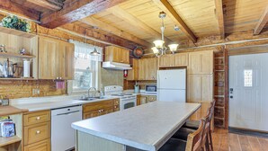 Une cuisine spacieuse avec des meubles en bois, un grand îlot central et des appareils électroménagers modernes.