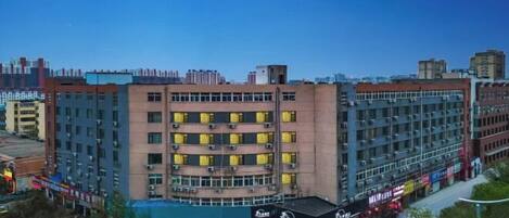 A multi-story hotel with a central courtyard, surrounded by various shops and restaurants.