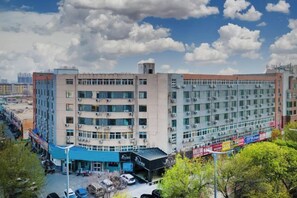 A multi-story building with a flat facade, large windows, and a parking area in front. - Lanting Hotel (Liaocheng Wanda Plaza Branch) (Liaocheng)