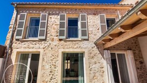 Un bâtiment en pierre doté de nombreuses fenêtres et d’un espace piscine.