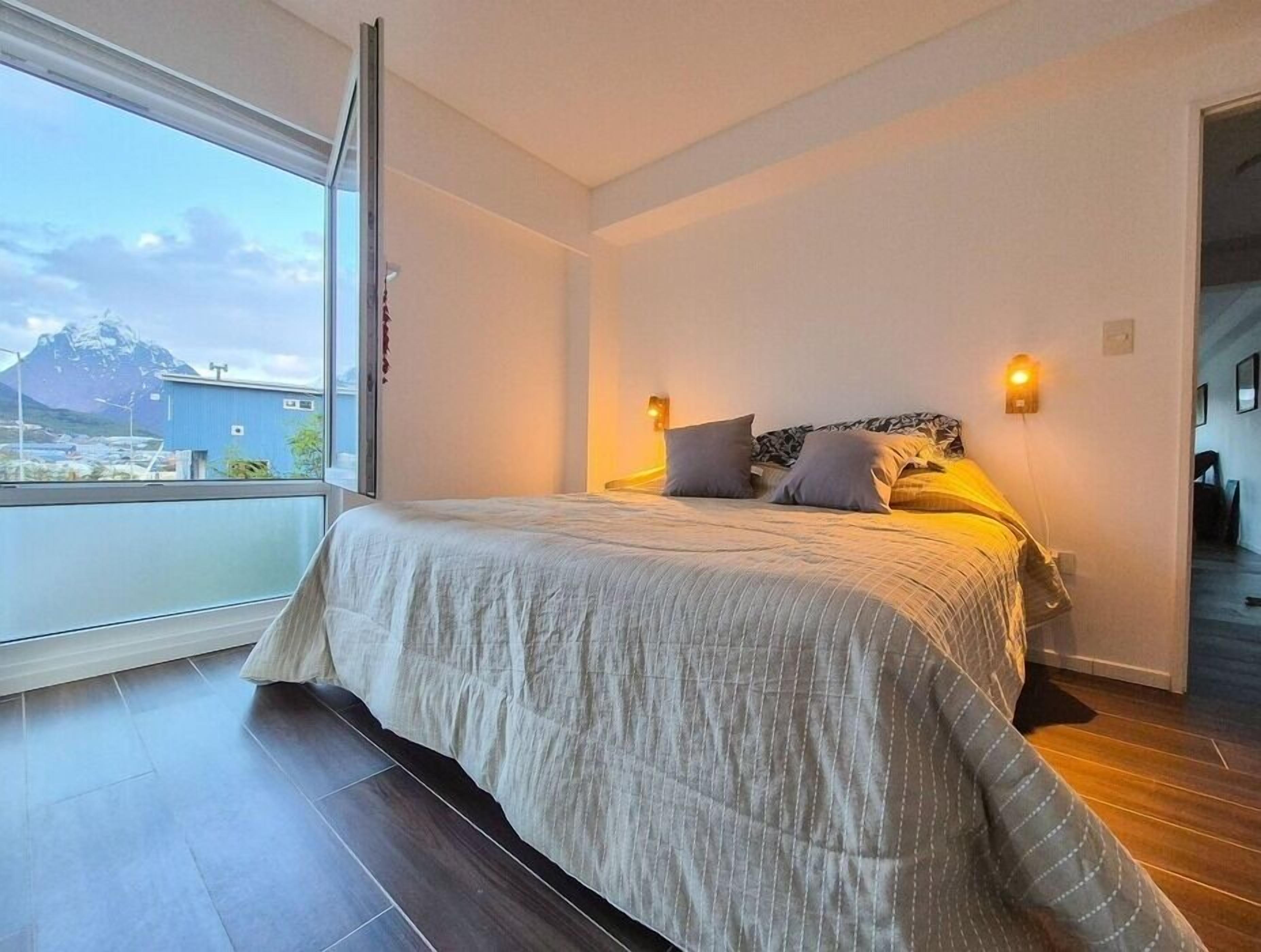 Une chambre avec un grand lit, une vue sur la montagne et un balcon.
