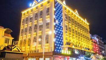 A multi-story hotel with illuminated signage and a prominent vertical light display on one side.
